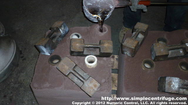 Pouring the lid. The weights help ensure the mold doesn't rise up during the pouring process.