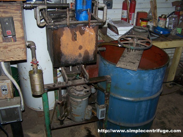 Your dandy centrifuge is inside that 1 cu.ft. box with the funnel thing on the top. At one point I calculated the speed at 4200 RPM, but I don't think it is running quite that fast. Oil drains from the bottom of the centrifuge box into the blue holding barrel.