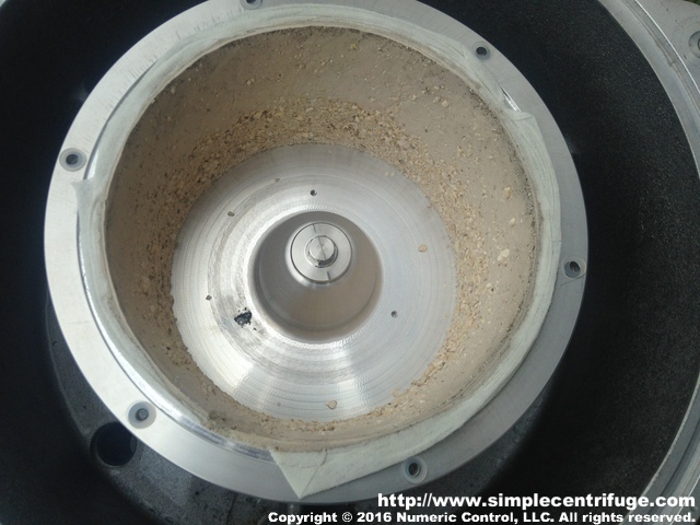 Once the lid is removed you can see how the filter paper (common paper towels) has captured the corn starch. The heavier clumps tended to collect near the bottom because despite the centrifugal forces you can't escape earths gravity. There was some concern that the coating would be heavier near the bottom but it appears fairly consistent aside from the clumps. A screen baffle would likely even it even more. Not the six nylon plastic washers to create the small gap between the rotor and the lid.