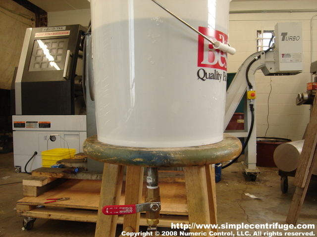 This is the finished bucket tank. I drilled a hole in the top of the stool so the pipe and valve could pass through. This is very easy to move around. I needed a setup in the shop to demonstrate the centrifuge.