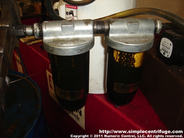 This shows my water trap ahead of the gear pump. The first filter housing is empty, no filter element, this creates a low spot in the line for large chunks and water to get captured. The second filter housing has a paper element and protects the pump from too much junk. I typically drain water from these traps each day. Water that makes it past the traps will settle in the heater, where it is drained. Any remaining water will be captured by the centrifuge. This shows my water trap ahead of the gear pump. The first filter housing is empty, no filter element, this creates a low spot in the line for large chunks and water to get captured. The second filter housing has a paper element and protects the pump from too much junk. I typically drain water from these traps each day. Water that makes it past the traps will settle in the heater, where it is drained. Any remaining water will be captured by the centrifuge.