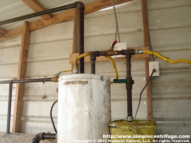 The upper red valve controls the flow to the centrifuge. It is only cracked enough to establish the desired gallons per hour. The lower green valve is a redirect which allow the operator to measure the flow rate. Experience is key to choosing the correct rate. Some oils run quickly and others slowly depending on the degree of contamination.