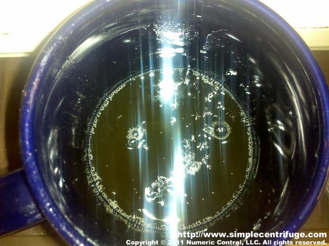 I heated a sample in the microwave for a few minutes. It is hard to tell from the photo but the oil is boiling which suggests it may contain water and or other contaminants. Hot oil should generally be fairly calm. The temperature measured with the IR gun was around 350F.