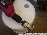 Making a five gallon bucket into a centrifuge feed tank is simple. Start by drilling a hole with a suitable hole saw.