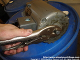 If you cannot lock the shaft with the screw driver you can remove the fan shroud and lock the shaft with a pair of locking pliers. No need to remove the motor from the machine. This photo is to demonstrate the process.