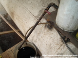 The drain has been replaced with a ball valve and directed to a bucket. Note the cap on the end of the pipe. These caps are placed to prevent leaks in the event a valve leaks or is opened by accident. The caps are removed and replaced after use.